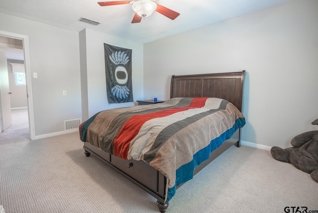 carpeted bedroom with a textured ceiling and ceiling fan