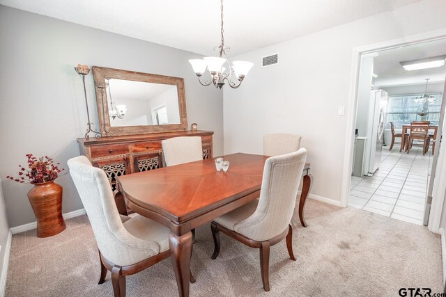 carpeted dining room featuring an inviting chandelier