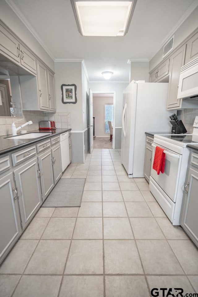 kitchen featuring sink, gray cabinetry, white appliances, and decorative backsplash