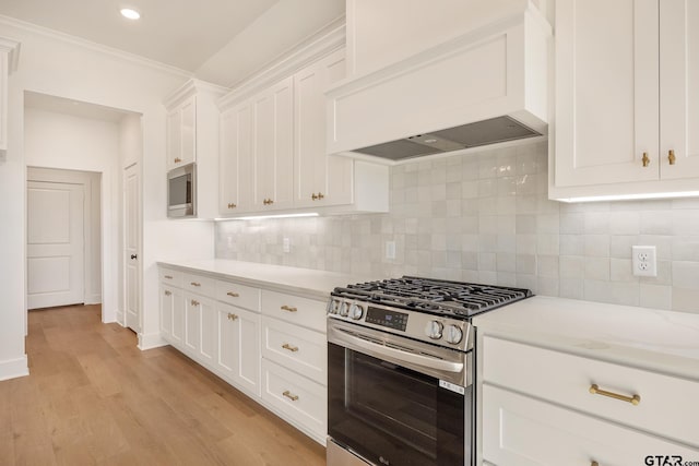 kitchen featuring white cabinetry, tasteful backsplash, light hardwood / wood-style floors, appliances with stainless steel finishes, and custom exhaust hood