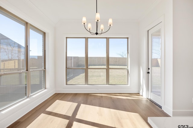 interior space with ornamental molding, a wealth of natural light, and an inviting chandelier