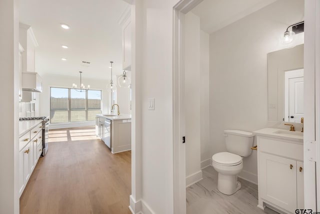 bathroom with vanity, a chandelier, and toilet