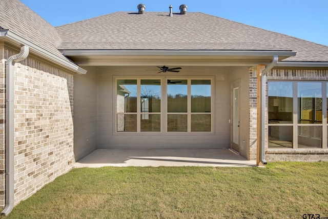 back of property with ceiling fan, a yard, and a patio