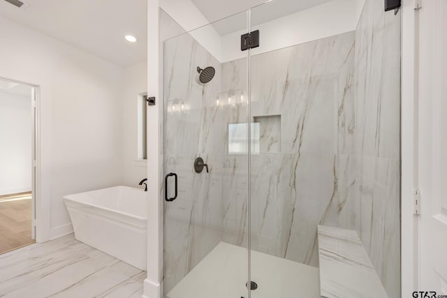 bathroom featuring separate shower and tub