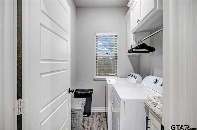 2609 Tulsa St, Tyler, TX 75702 - laundry area featuring washer and clothes dryer, cabinet space, wood finished floors, and a textured wall