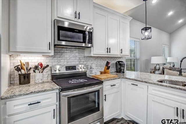 2609 Tulsa St, Tyler, TX 75702 - kitchen with appliances with stainless steel finishes, tasteful backsplash, vaulted ceiling, white cabinetry, and light stone counters