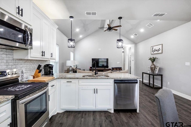 2609 Tulsa St, Tyler, TX 75702 - kitchen with stainless steel appliances, a peninsula, dark wood finished floors, ceiling fan, and white cabinetry