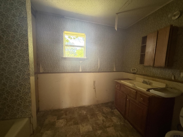 bathroom featuring wallpapered walls, toilet, vanity, and a bathtub