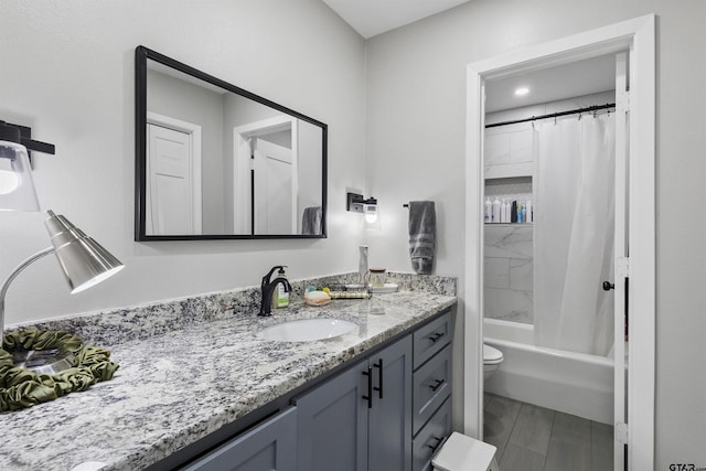 full bathroom featuring vanity, hardwood / wood-style floors, shower / tub combo with curtain, and toilet