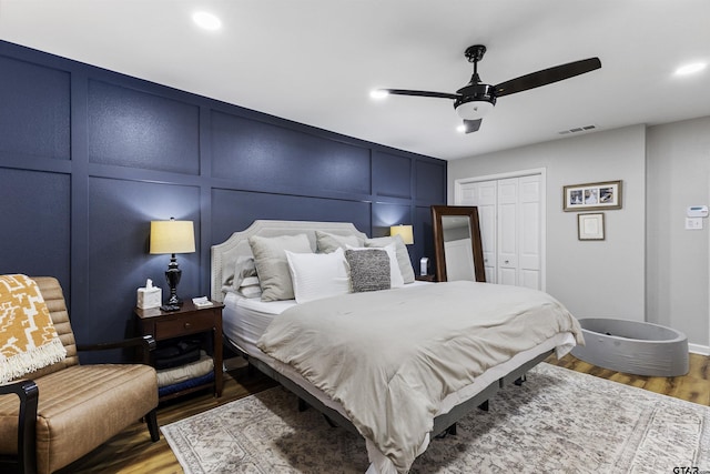 bedroom featuring hardwood / wood-style floors, a closet, and ceiling fan