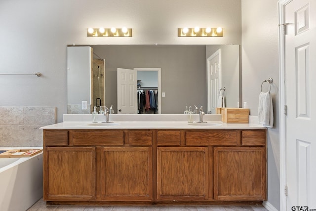 full bathroom featuring a sink, double vanity, a shower stall, and a bath