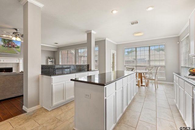 kitchen with visible vents, baseboards, crown molding, and ceiling fan