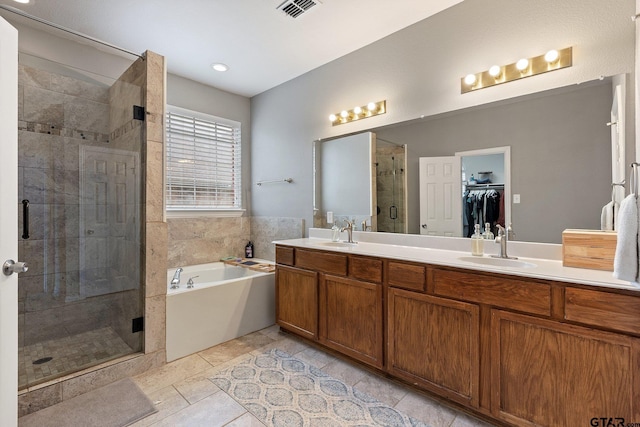 bathroom featuring visible vents, double vanity, a garden tub, a shower stall, and a sink