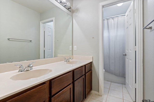 bathroom with double vanity, curtained shower, a sink, and tile patterned flooring