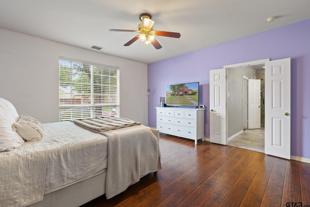 bedroom with baseboards, ceiling fan, wood-type flooring, and visible vents