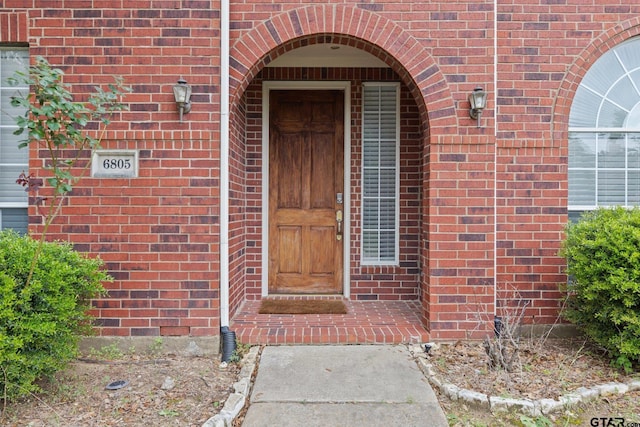 entrance to property featuring brick siding