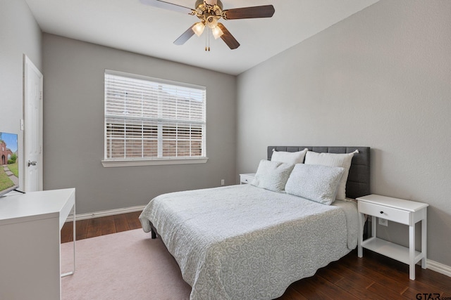 bedroom with baseboards, a ceiling fan, and dark wood-style floors