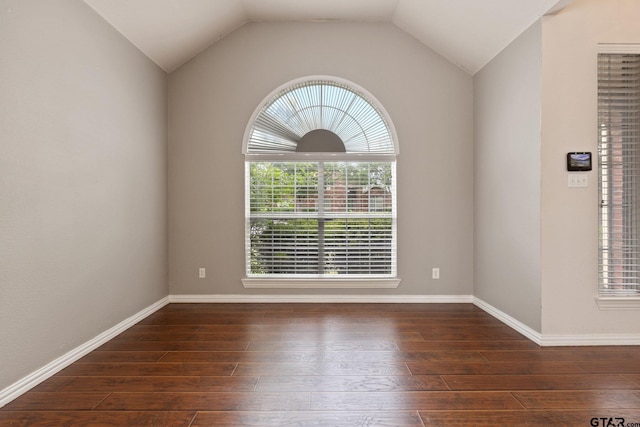 unfurnished room with wood-type flooring, baseboards, and vaulted ceiling