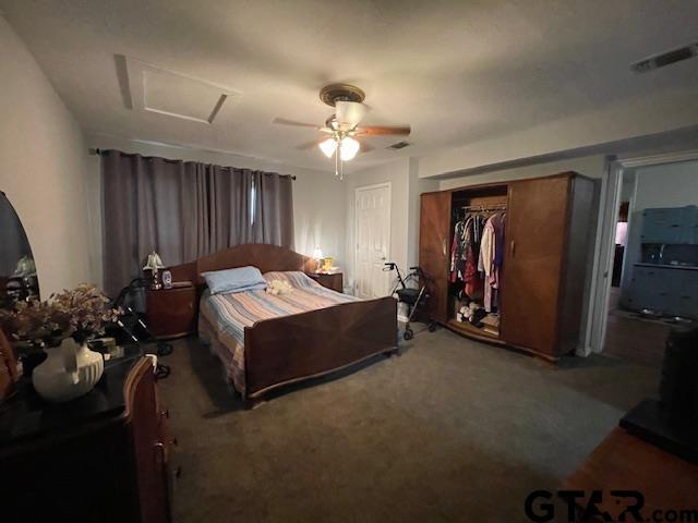 carpeted bedroom with ceiling fan and a closet