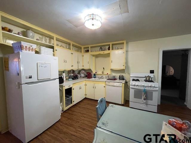 kitchen with dark wood-type flooring, white appliances, and sink