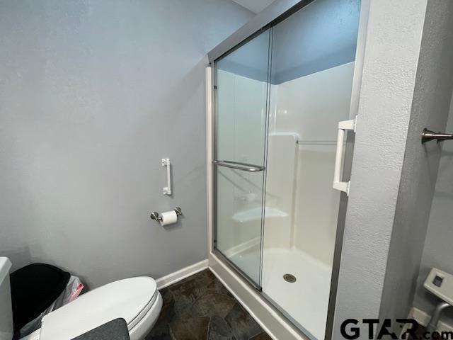 bathroom with toilet and walk in shower