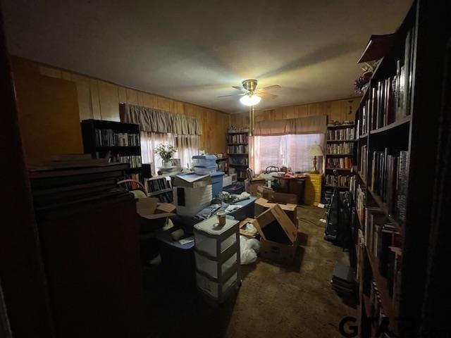 home office featuring ceiling fan, carpet floors, and wood walls