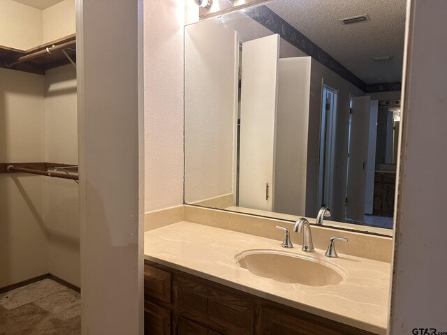 2203 S Williams Ave, Mount Pleasant, TX 75455 - bathroom featuring visible vents, a textured ceiling, and vanity