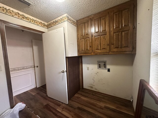 2203 S Williams Ave, Mount Pleasant, TX 75455 - washroom with cabinet space, dark wood-type flooring, a textured ceiling, and washer hookup
