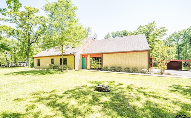 back of property with brick siding and a lawn