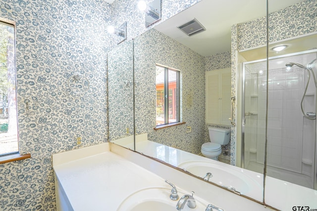 bathroom with toilet, an enclosed shower, wallpapered walls, and a sink