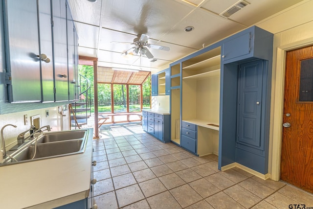 kitchen featuring visible vents, a sink, ceiling fan, light countertops, and blue cabinetry