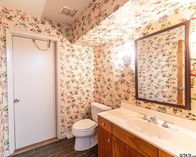 full bath with toilet, wallpapered walls, vanity, and visible vents