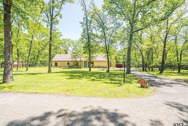 single story home featuring gravel driveway and a front lawn