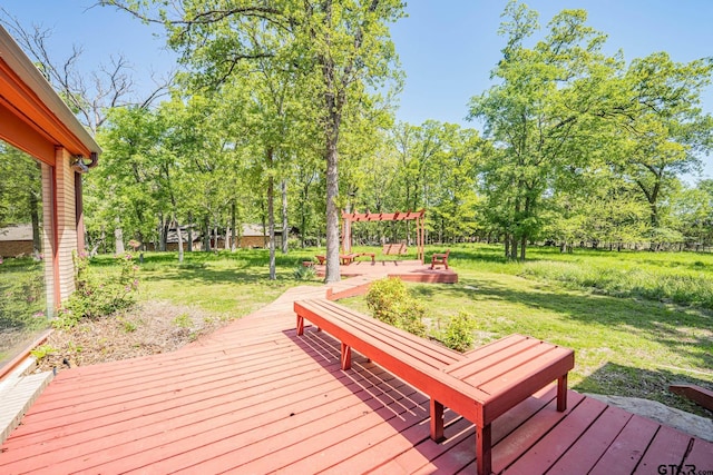 wooden deck featuring a yard and a pergola