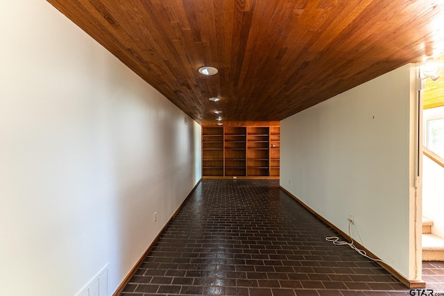 hallway featuring visible vents, built in shelves, baseboards, wood ceiling, and recessed lighting