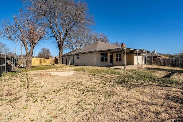 rear view of property with a patio and a lawn