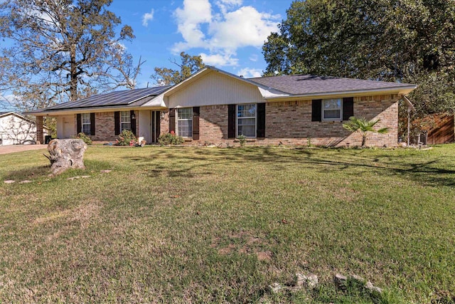 ranch-style home with solar panels and a front yard