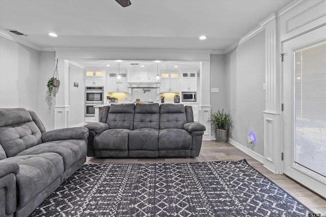 living room featuring hardwood / wood-style flooring and ornamental molding