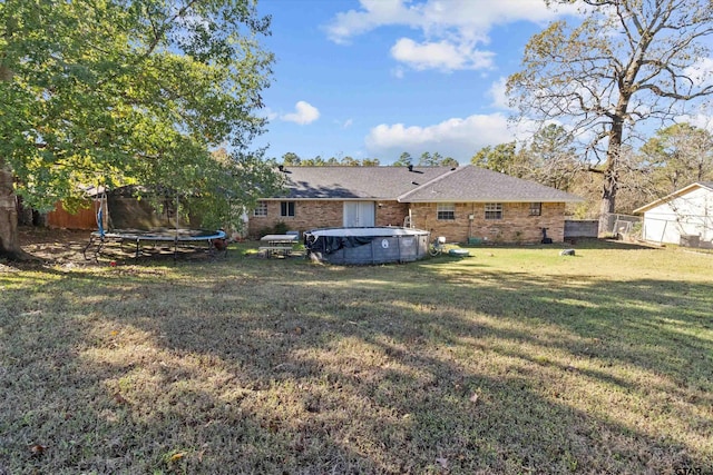 view of yard featuring a trampoline and a covered pool