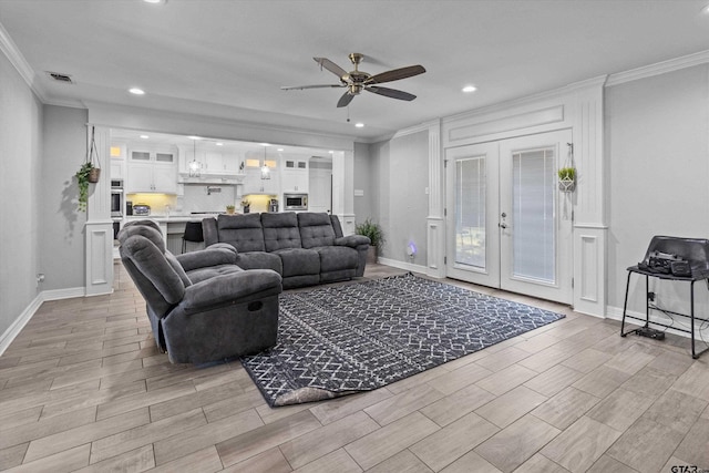 living room with french doors, ceiling fan, and crown molding