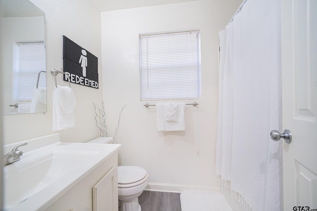 bathroom with toilet, hardwood / wood-style floors, and vanity