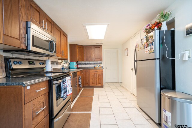 kitchen with decorative backsplash, sink, stainless steel appliances, and light tile patterned flooring