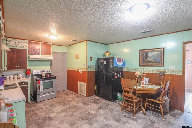 2391 Fm 16 W, Tyler, TX 75706 - kitchen with stainless steel range with electric cooktop, freestanding refrigerator, wood walls, wainscoting, and ornamental molding