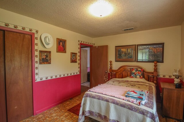 2391 Fm 16 W, Tyler, TX 75706 - bedroom featuring a textured ceiling and tile patterned floors