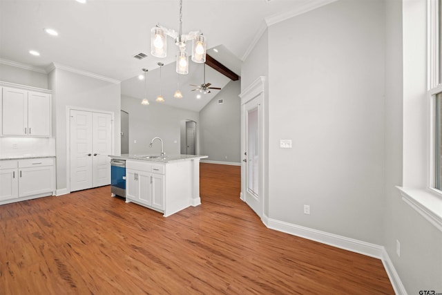 kitchen with white cabinets, ceiling fan with notable chandelier, hardwood / wood-style flooring, and an island with sink