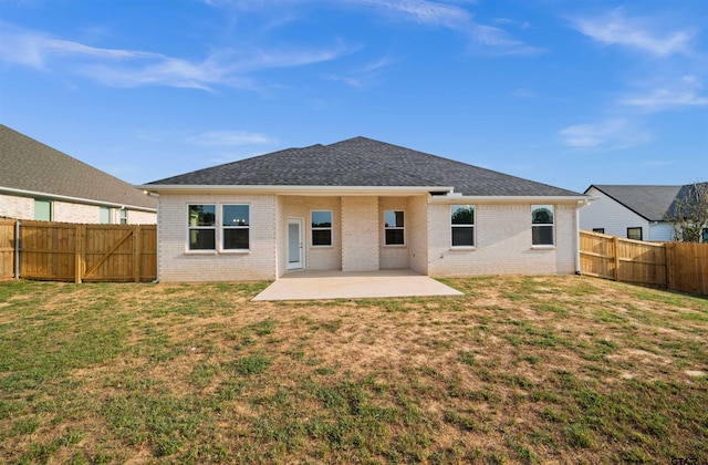 rear view of house with a patio and a yard