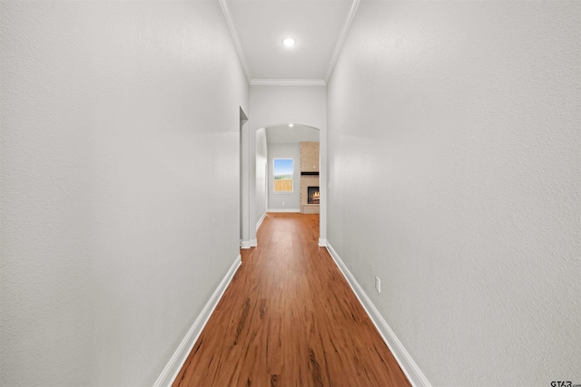 hallway with hardwood / wood-style floors and crown molding