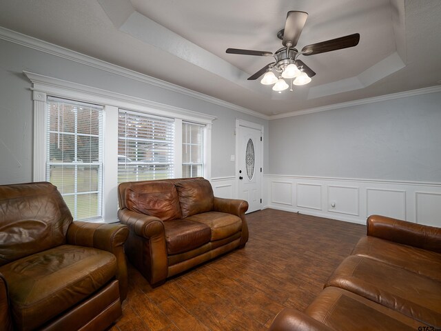 living room with dark hardwood / wood-style floors, a raised ceiling, ceiling fan, and crown molding