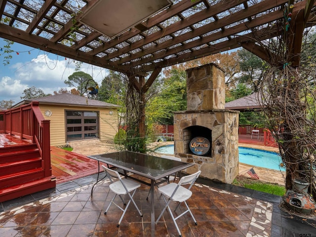 view of patio with an outdoor stone fireplace and a pergola