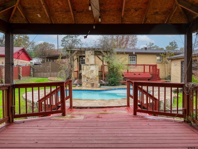 wooden deck featuring a gazebo and a fenced in pool